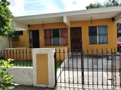 a yellow house with a gate in front of it at Cozy Apartment Studio in Santo Domingo