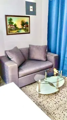 a living room with a purple couch and a table at Cozy Apartment Studio in Santo Domingo