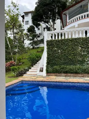 a blue swimming pool in front of a house at Villa Celeste Bed & Breakfast in El Río Arriba