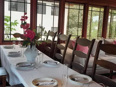 a table with a vase of flowers on it at Villa Celeste Bed & Breakfast in El Río Arriba