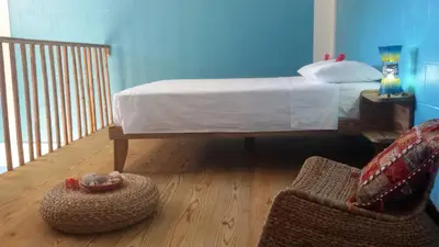 a bedroom with a bed and a chair in a room at B&B El Mirador al Mar in Sosúa