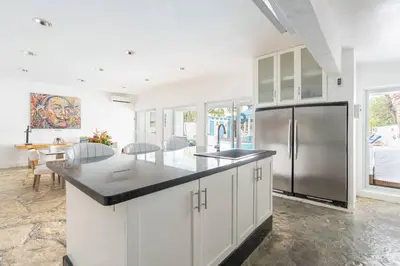 a kitchen with white cabinets and a stainless steel refrigerator at Dolce Casa in Juan Dolio