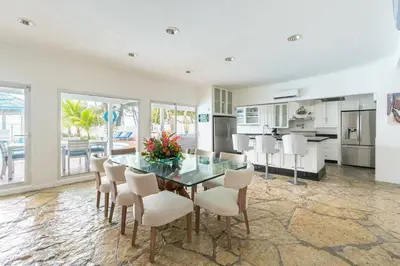 a kitchen and dining room with a glass table and chairs at Dolce Casa in Juan Dolio
