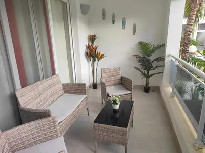 a balcony with wicker chairs and a coffee table at Estrella Dominicus - Excepcional Apartamento en el Caribe in Bayahibe