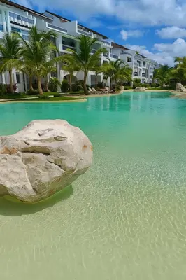a rock sitting on the beach next to a building at Estrella Dominicus - Excepcional Apartamento en el Caribe in Bayahibe