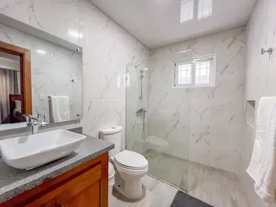 a bathroom with a toilet and a sink and a shower at New 2BR APT in Sosua town, close to strip and next to supermarket in Sosúa