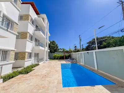 a swimming pool in front of a building at New 2BR APT in Sosua town, close to strip and next to supermarket in Sosúa
