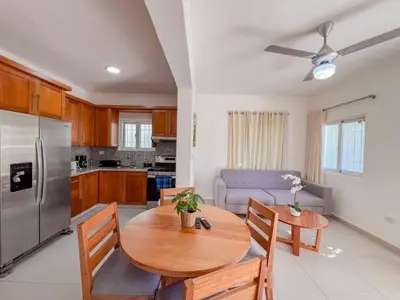 a kitchen and living room with a wooden table at New 2BR APT in Sosua town, close to strip and next to supermarket in Sosúa