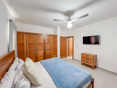 a bedroom with a bed and a flat screen tv at New 2BR APT in Sosua town, close to strip and next to supermarket in Sosúa