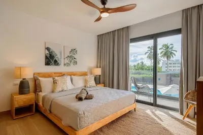 a bedroom with a bed and a sliding glass door at New pool views Sausalito Residencial close to Playa Bavaro in Punta Cana