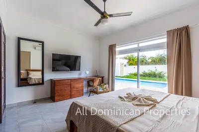 a bedroom with a bed and a mirror and a tv at Villas Santa Fe in Sosúa