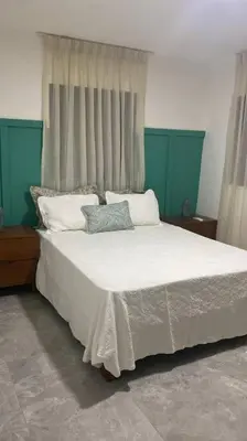 a bedroom with a white bed with two pillows at Aire acondicionado Proximo teleférico y ocean Word in San Felipe de Puerto Plata