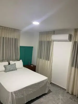 a bedroom with a white bed and a window at Aire acondicionado Proximo teleférico y ocean Word in San Felipe de Puerto Plata