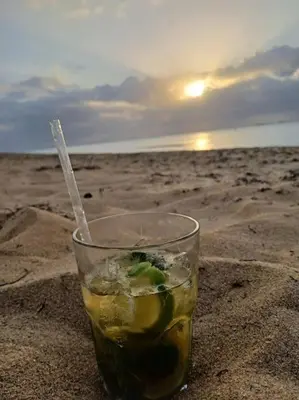 a drink sitting in the sand on the beach at En Plaza Center Penthouse con 3 terrazas en el centro de Las Terrenas la playa està a 5 min a pied in Las Terrenas