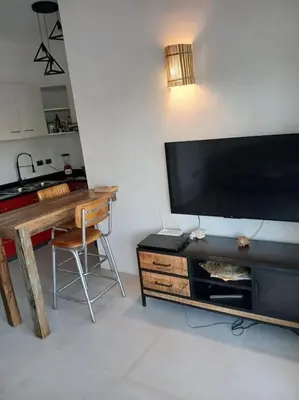 a living room with a table and a large television at En Plaza Center Penthouse con 3 terrazas en el centro de Las Terrenas la playa està a 5 min a pied in Las Terrenas