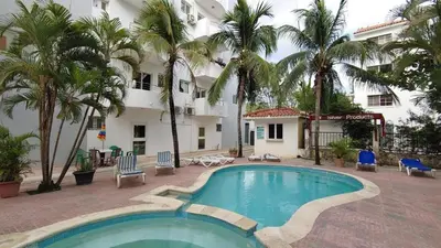 a pool in front of a hotel with palm trees at Juan Dolio,Beach, Pool, 40