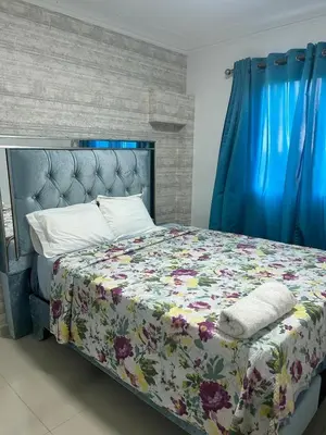 a bedroom with a bed with a floral comforter at Apartamento con Deslumbrante Vista Al Mar in La Francia