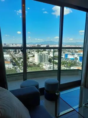 a bedroom with a view of a city from a window at Luxury penthouse con jacuzzi privado, Gym, pool in Santo Domingo