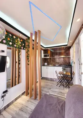 a living room with a kitchen with wooden floors at Aparta hoteles Corales del Sur in La Viva