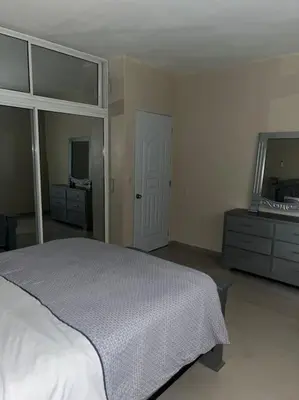 a bedroom with a bed and a dresser and a mirror at Maison T4, près de la mer in La Romana
