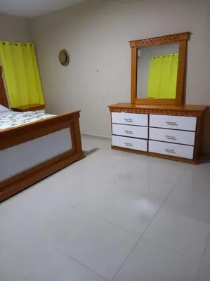 a bedroom with two beds and a dresser with a mirror at Maison T4, près de la mer in La Romana