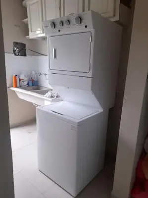 a white kitchen with a stove and a refrigerator at Maison T4, près de la mer in La Romana