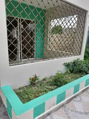 a fence on the side of a building with plants at Maison T4, près de la mer in La Romana