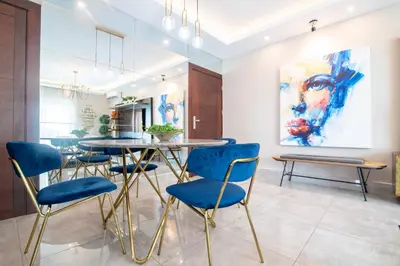 a dining room with a table and blue chairs at Exclusivo apartamento - Soha Suites II-B9 - 2 BR in Rincón Largo