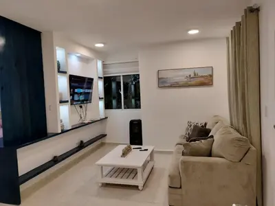 a living room with a couch and a table at Agréable appartement en rooftop in La Cabirma