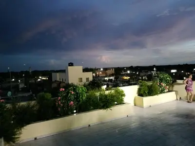 a woman standing on top of a balcony at night at Agréable appartement en rooftop in La Cabirma