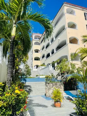 a building with a palm tree in front of it at Apartamento en la playa 1A - Residencial Marina Bay in Cuevas