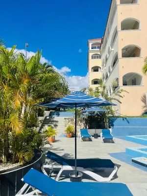 a patio with chairs and an umbrella and a pool at Apartamento en la playa 1A - Residencial Marina Bay in Cuevas