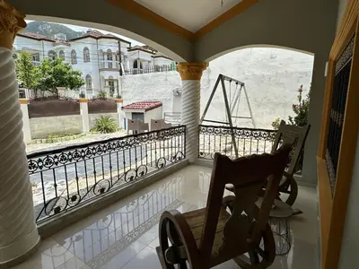 a rocking chair on a balcony with a view of a building at Casa completa con hermosa vista in San Felipe de Puerto Plata