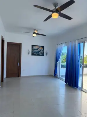 a living room with a ceiling fan and blue curtains at Timeless Luxury Villa-Ocean View 3BRM-5Bath-Pool in San Felipe de Puerto Plata