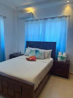 a bedroom with a bed with blue walls and blue curtains at Timeless Luxury Villa-Ocean View 3BRM-5Bath-Pool in San Felipe de Puerto Plata