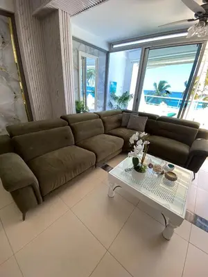 a living room with a brown couch and a table at LasOlasTower JuanDolio-2Br-3Bds-7Px-WiFi-SeaView in Juan Dolio