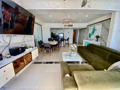 a living room with a green couch and a table at LasOlasTower JuanDolio-2Br-3Bds-7Px-WiFi-SeaView in Juan Dolio
