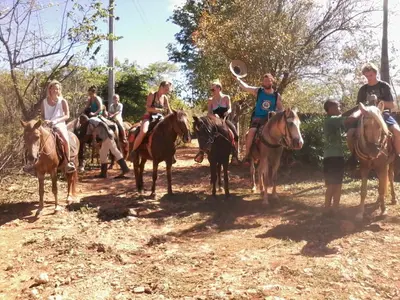 a group of people riding horses on a dirt road at La Rancheta in Las Galeras