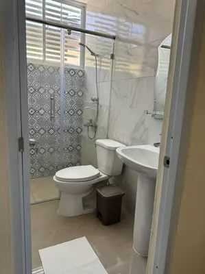 a white bathroom with a toilet and a sink at Apartamento hermoso in Los Macos