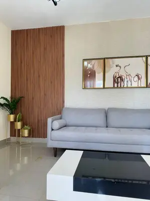 a living room with a blue couch and a mirror at Apartamento hermoso in Los Macos