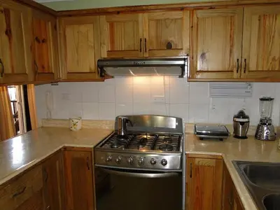 a kitchen with a stainless steel stove and wooden cabinets at Apartamento Carmil I in Santo Domingo