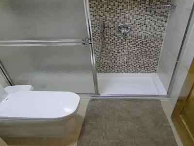 a bathroom with a white toilet and a shower at Apartamento Carmil I in Santo Domingo