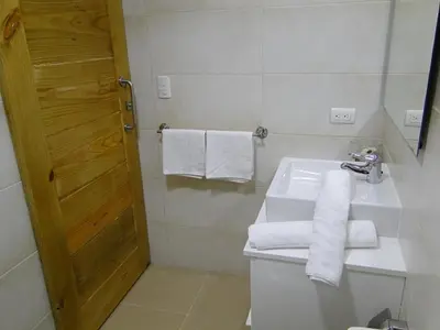 a bathroom with a sink and a toilet and towels at Apartamento Carmil I in Santo Domingo