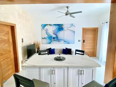 a living room with a ceiling fan and a tv at Fantástico apartamento céntrico Playa a 100 mts in Río San Juan