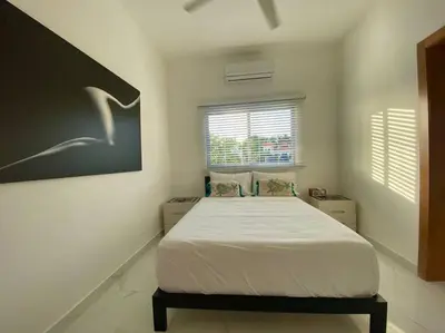 a bedroom with a bed in a white room at Fantástico apartamento céntrico Playa a 100 mts in Río San Juan