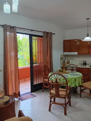 a dining room with a table and chairs and a kitchen at Residenzia Oasis Fiordaliza in El Higo