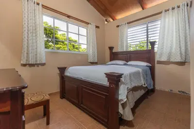 a bedroom with a bed and two windows at Casa Palmar in Palmar Arriba