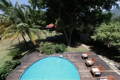 an empty swimming pool with chairs and a palm tree at Casa Palmar - Finca in Palmar Arriba