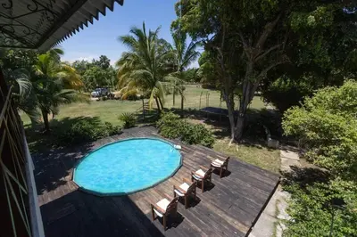 a swimming pool with chairs on a wooden deck at Casa Palmar - Finca in Palmar Arriba