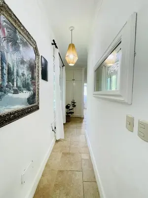 a hallway with white walls and a painting on the wall at Victorian Condominio in Cabarete